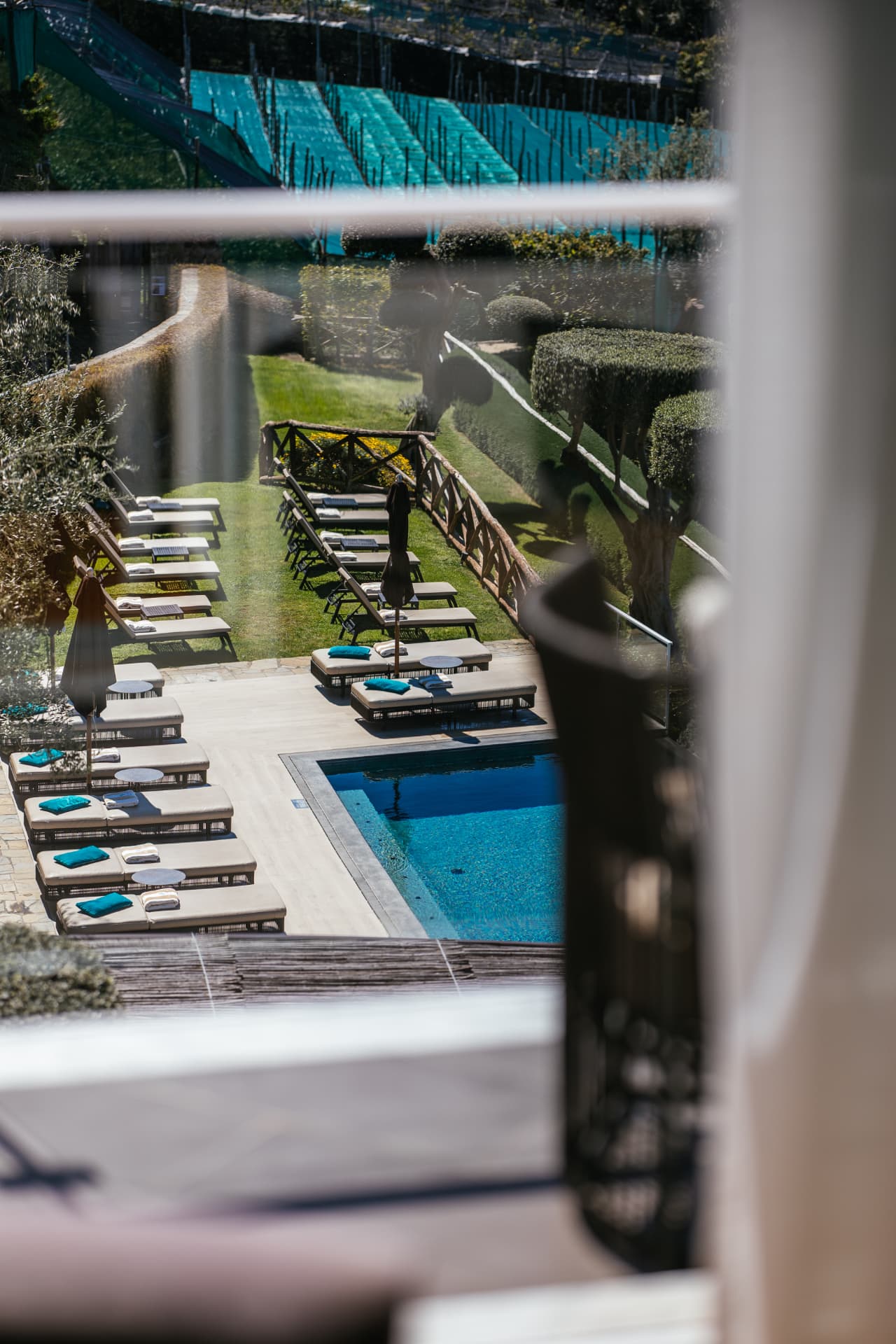 The pool and sun terrace seen through a guest room window